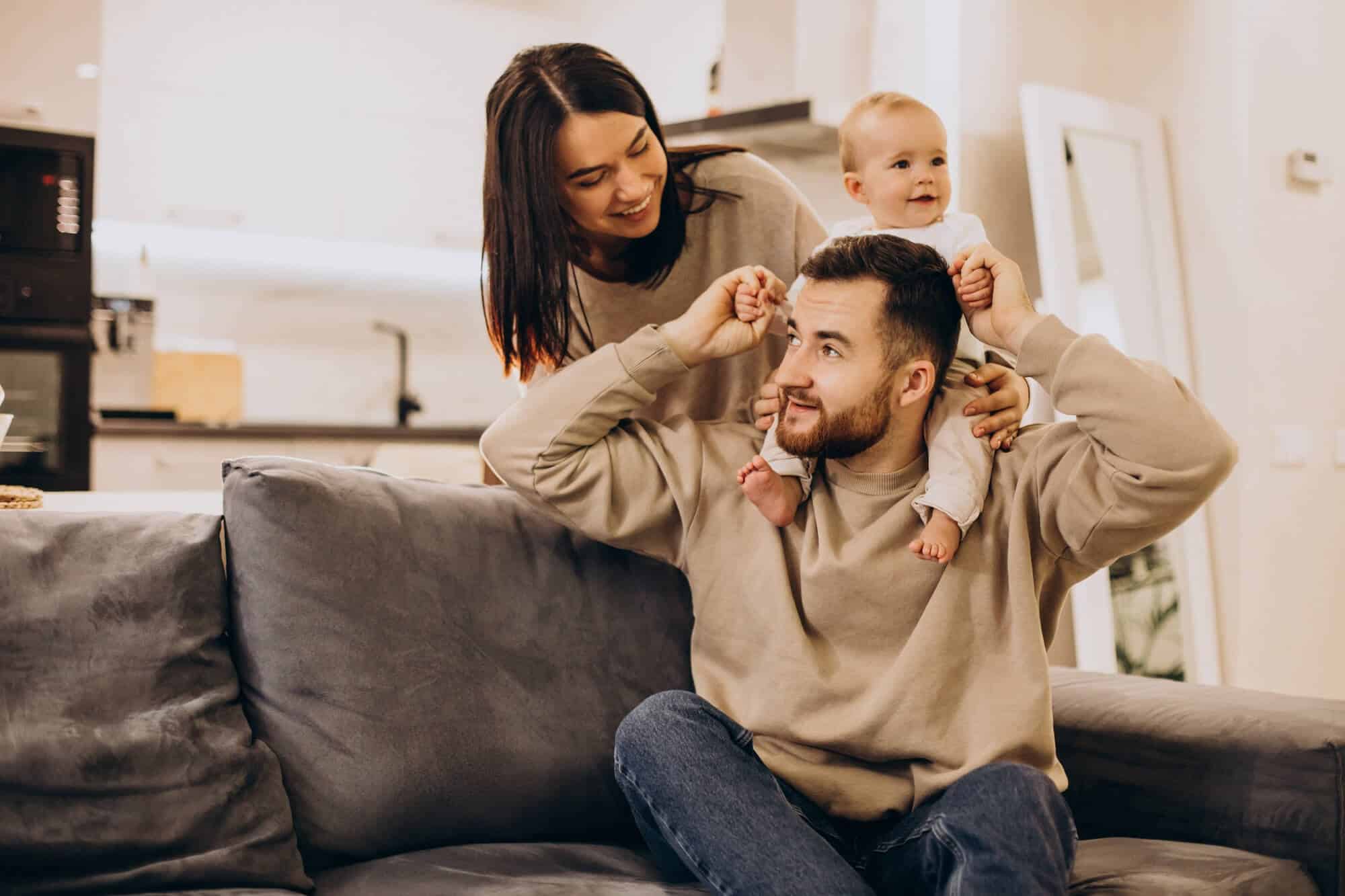 young-family-with-baby-toddler-girl-home-sitting-sofa